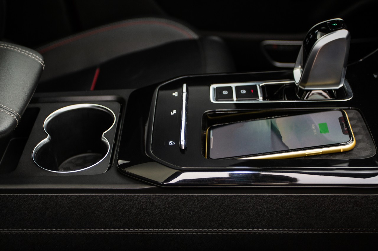 Wireless mobile charger in the modern car. Portable wireless car charger for smartphone. Phone charging on  wireless charger.